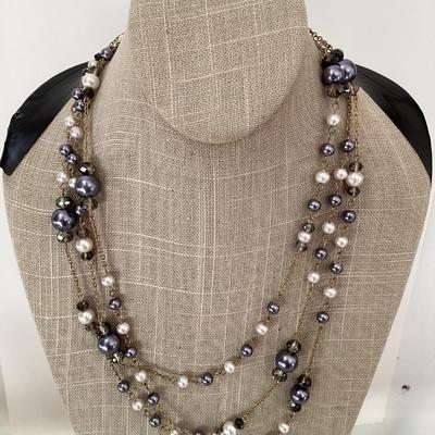 Multi strand necklace with purple and white beads