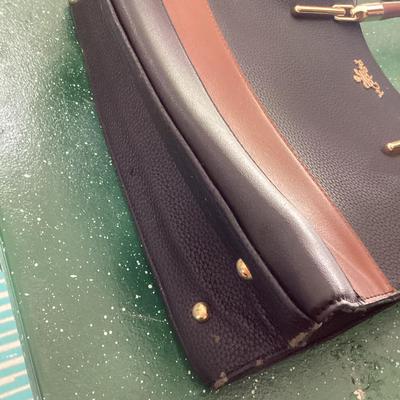 black and brown hand bag labeled Prada