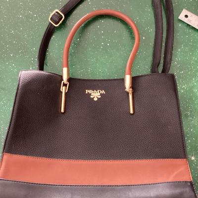 black and brown hand bag labeled Prada