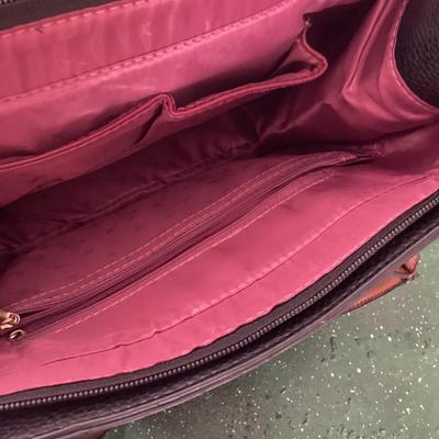 black and brown hand bag labeled Prada