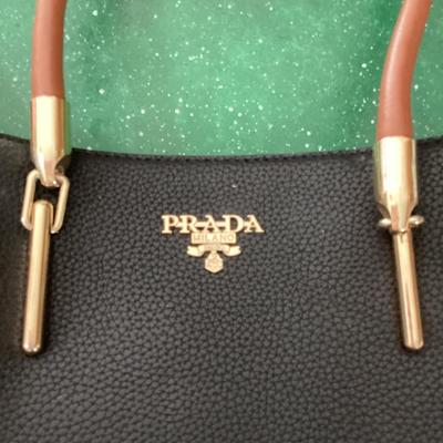 black and brown hand bag labeled Prada