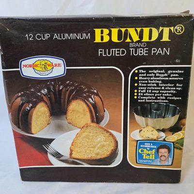 Lot 111: Bakers Delight: Bundt Pan in Box, Covered Cake Plate, Square Bundt Pan, Apple Pie Recipe Pie Plate,