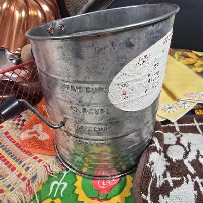 LOT 123: Copper Bundt Pans with Vintage Kitchen Gadgets and Cookie Cutters, Betty Crocker Points, Aprons, Tea Towels and Napkins