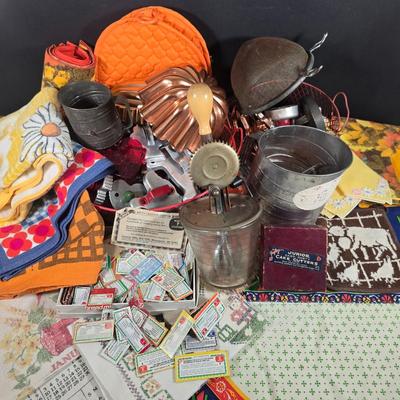 LOT 123: Copper Bundt Pans with Vintage Kitchen Gadgets and Cookie Cutters, Betty Crocker Points, Aprons, Tea Towels and Napkins