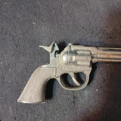 PET TOY CAP GUN WITH A BOX OF ROLLED CAPS AND A SMALLER METAL TOY GUN