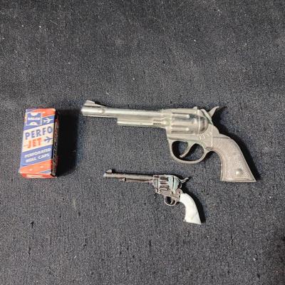PET TOY CAP GUN WITH A BOX OF ROLLED CAPS AND A SMALLER METAL TOY GUN