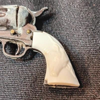 PET TOY CAP GUN WITH A BOX OF ROLLED CAPS AND A SMALLER METAL TOY GUN