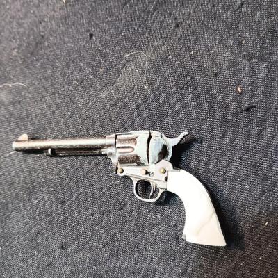 PET TOY CAP GUN WITH A BOX OF ROLLED CAPS AND A SMALLER METAL TOY GUN
