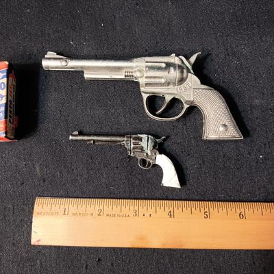 PET TOY CAP GUN WITH A BOX OF ROLLED CAPS AND A SMALLER METAL TOY GUN