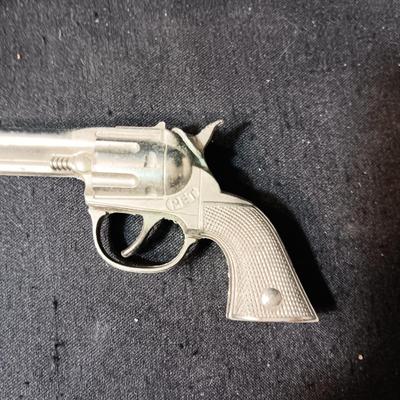 PET TOY CAP GUN WITH A BOX OF ROLLED CAPS AND A SMALLER METAL TOY GUN