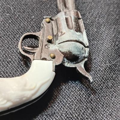 PET TOY CAP GUN WITH A BOX OF ROLLED CAPS AND A SMALLER METAL TOY GUN
