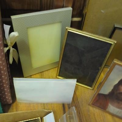Picture frames of different sizes, and materials - with a large, quilted photo album