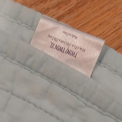 Twin sized bedspread with pillowcases with a Soft Twin blue blanket, a decorative pattern throw, and a quilted Doiley