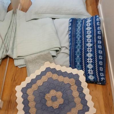 Twin sized bedspread with pillowcases with a Soft Twin blue blanket, a decorative pattern throw, and a quilted Doiley