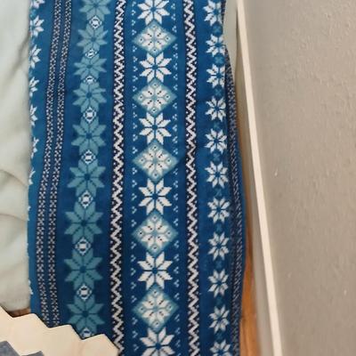 Twin sized bedspread with pillowcases with a Soft Twin blue blanket, a decorative pattern throw, and a quilted Doiley