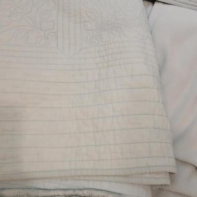 Twin sized bedspread with pillowcases with a Soft Twin blue blanket, a decorative pattern throw, and a quilted Doiley