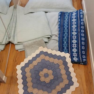 Twin sized bedspread with pillowcases with a Soft Twin blue blanket, a decorative pattern throw, and a quilted Doiley