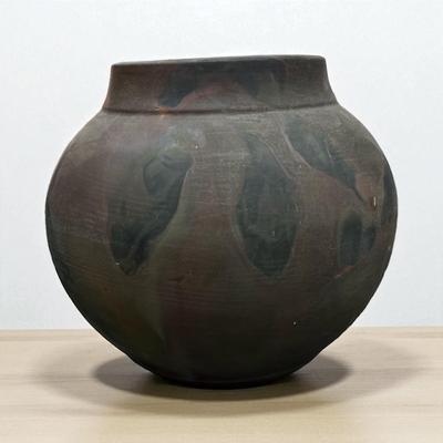Sale Photo Thumbnail #76: Tony Evans (1942-2009) Raku Pottery Vase.  His Raku pottery features a distinctive volcanic surface and earthy tones and glossy interior drip glaze.
Approximately 14" wideX13" Tall  Opening 7.5"