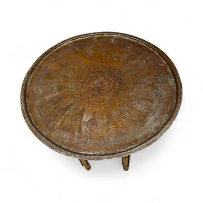 Sale Photo Thumbnail #117: Moroccan Brass Tray Top Table.  Characterized by its intricately engraved brass top and a foldable wooden base.
Approximate Measurements   26.5" Round and 20" Tall