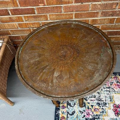 Sale Photo Thumbnail #118: Moroccan Brass Tray Top Table.  Characterized by its intricately engraved brass top and a foldable wooden base.
Approximate Measurements   26.5" Round and 20" Tall
