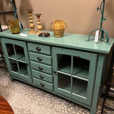 Sale Photo Thumbnail #160: Teal Buffet/Console Cabinet with Dual Glass Doors and Three Center Mounted Drawers.  Does Not Include item on top of the cabinet
62"X18"X35"