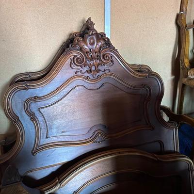 Sale Photo Thumbnail #18: Elegant vintage bed set in solid wood—likely walnut or oak—with an ornate, rococo-inspired headboard featuring scrolls, shells, and foliate carving. The footboard echoes the curves with a shaped crest and serpentine rails, giving the bed a graceful, s