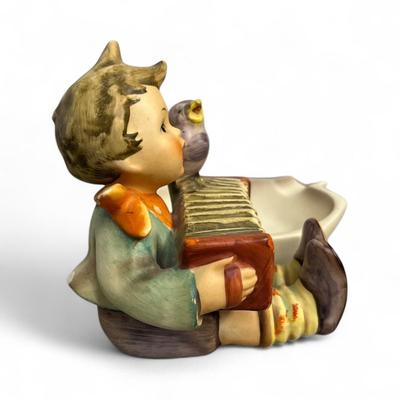 Sale Photo Thumbnail #391: Goebel Hummel Let's Sing Ashtray or Trinket dish #114   Boy Playing an accordion and a bird  Chip on the rear on the coat