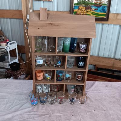 A COLLECTION OF SHOT GLASSES AND A HOUSE SHAPED WALL SHELF