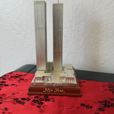 Sale Photo Thumbnail #23: – Detailed silver-tone replica of New York’s Twin Towers on a wooden base.
