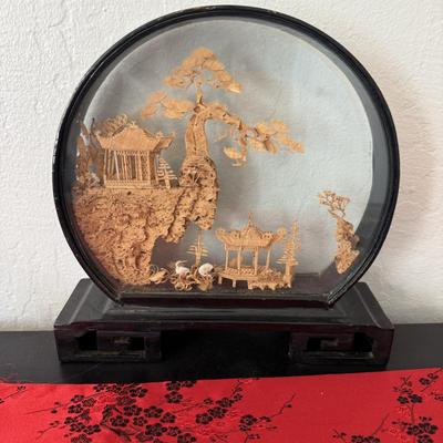 Sale Photo Thumbnail #25: Intricate carved landscape with temples, trees, and cranes in a round glass frame on a wooden stand.