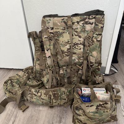 Sale Photo Thumbnail #31: Heavy-duty AKmax Outdoor rucksack system in multicam pattern with multiple attachments. Includes large framed rucksack, hydration carrier, detachable utility pouch, padded hip belt, and additional modular pieces. Built for rugged use, camping, hiking, or 