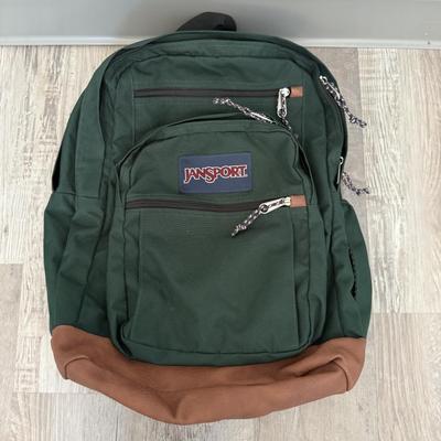Sale Photo Thumbnail #49: Classic green Jansport backpack with leather bottom and multiple zip compartments.