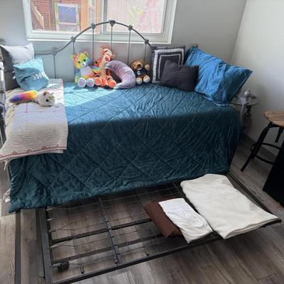 Sale Photo Thumbnail #65: Charming metal-framed daybed with teal quilted cover and accent pillows. Comes with a pull-out trundle frame beneath for extra sleeping space. Perfect for a guest room or small bedroom.