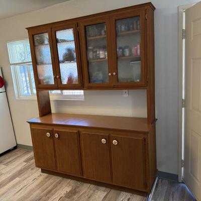 Sale Photo Thumbnail #156: Classic two-piece wooden hutch featuring upper cabinets with textured glass doors and lower storage with solid wood doors. The spacious countertop makes it perfect for use as a buffet, kitchen storage, or dining room display. Sturdy and functional with a 