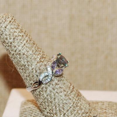 Size 7 ½ Iridescent Round Main 4 Prong Stone Ring with 4 "Leaves" of Light Purple Accent Stones on a Silver Tone Band (2.9g)