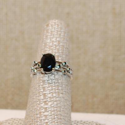 Size 7 All Black Oval Stone Ring with 8 Tiny Encircled Black Stones on a Silver Tone Band ( 3.3g)