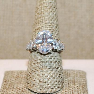 Size 8 Large Oval Clear Stone Ring with 8 Diamond Shape Side Accents on a Silver Tone Band (5.0g)