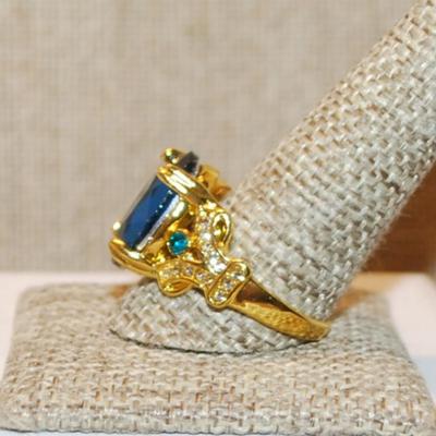 Size 11½ Large Blue Oval 4 Prong Stone Party Style Ring with Side Accents on a Gold Tone Band (8.2g)