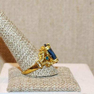 Size 11½ Large Blue Oval 4 Prong Stone Party Style Ring with Side Accents on a Gold Tone Band (8.2g)