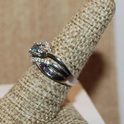Size 7 ½ Iridescent Round Stone Ring with Swirl Accents on a Split Silver Tone Band (4.3g)