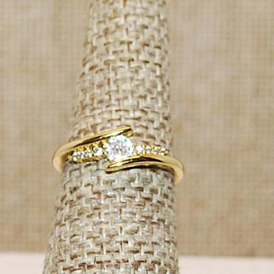 Size 6 ¼ Single Round Clear Main Stone with Side Accents on an Overlap Style Gold Tone Band (2.0g)