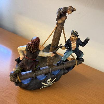 Sale Photo Thumbnail #216: Fun and detailed resin pirate figurine designed as a wine bottle holder. Features two pirates in battle aboard a ship with a skull-and-crossbones base. A unique and playful way to display a favorite bottle—perfect for nautical décor lovers or collector