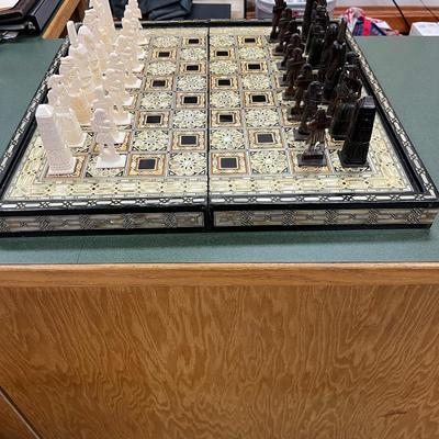 Sale Photo Thumbnail #841: Mosaic style inlaid Chess Set with Mother of Pearl.  The set includes 32 chess pieces, divided into dark and light colors.  One piece is broken (See Photo).  Has Backgammon on the flip side.