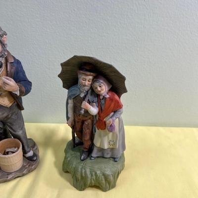 2 Porcelain Bisque Figurines; Stock Broker and Old Man & Woman w/Umbrella. 