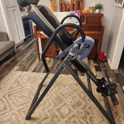 Sale Photo Thumbnail #21: Innova inversion therapy table featuring adjustable lumbar support and a six-position height-adjustment system. The table is made from a durable steel frame with comfortable padded backrest and ankle holders. Includes ergonomic handles and a safety strap 