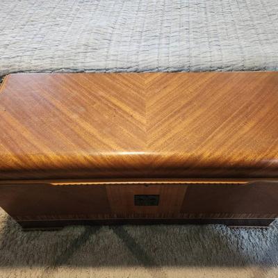 Sale Photo Thumbnail #16: Lane cedar chest featuring a wood veneer exterior with chevron pattern detailing on the lid and sides. Interior lined with cedar wood, includes green felt-lined storage compartments for smaller items. Retains Lane branding and authenticity markings. Vinta