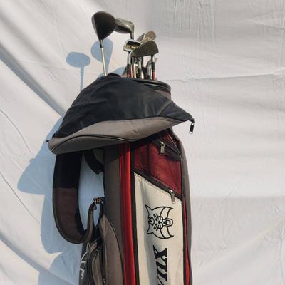 Sale Photo Thumbnail #22: Lynx golf bag containing a variety of golf clubs, including drivers and irons. Brands include Satellite (MX-Plus 3), Dunlop Gold, and others. The bag features a multi-compartment design with zippered pockets and an adjustable strap for portability. The cl