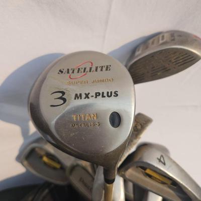 Sale Photo Thumbnail #24: Lynx golf bag containing a variety of golf clubs, including drivers and irons. Brands include Satellite (MX-Plus 3), Dunlop Gold, and others. The bag features a multi-compartment design with zippered pockets and an adjustable strap for portability. The cl