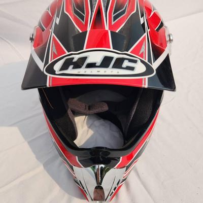 Sale Photo Thumbnail #41: HJC CL-XY1 motocross helmet featuring bold red and black graphic designs. Size XL, constructed for motocross and off-road use. Includes a visor for sun protection, interior padding for comfort, and a durable outer shell. Appears in good condition with no 