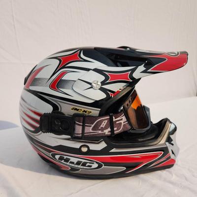 Sale Photo Thumbnail #51: HJC off-road motorcycle helmet featuring a striking red, black, and white graphic design. Includes an adjustable visor and built-in mounting points. Comes with tinted goggles for eye protection. Designed for off-road use, this helmet is lightweight and of